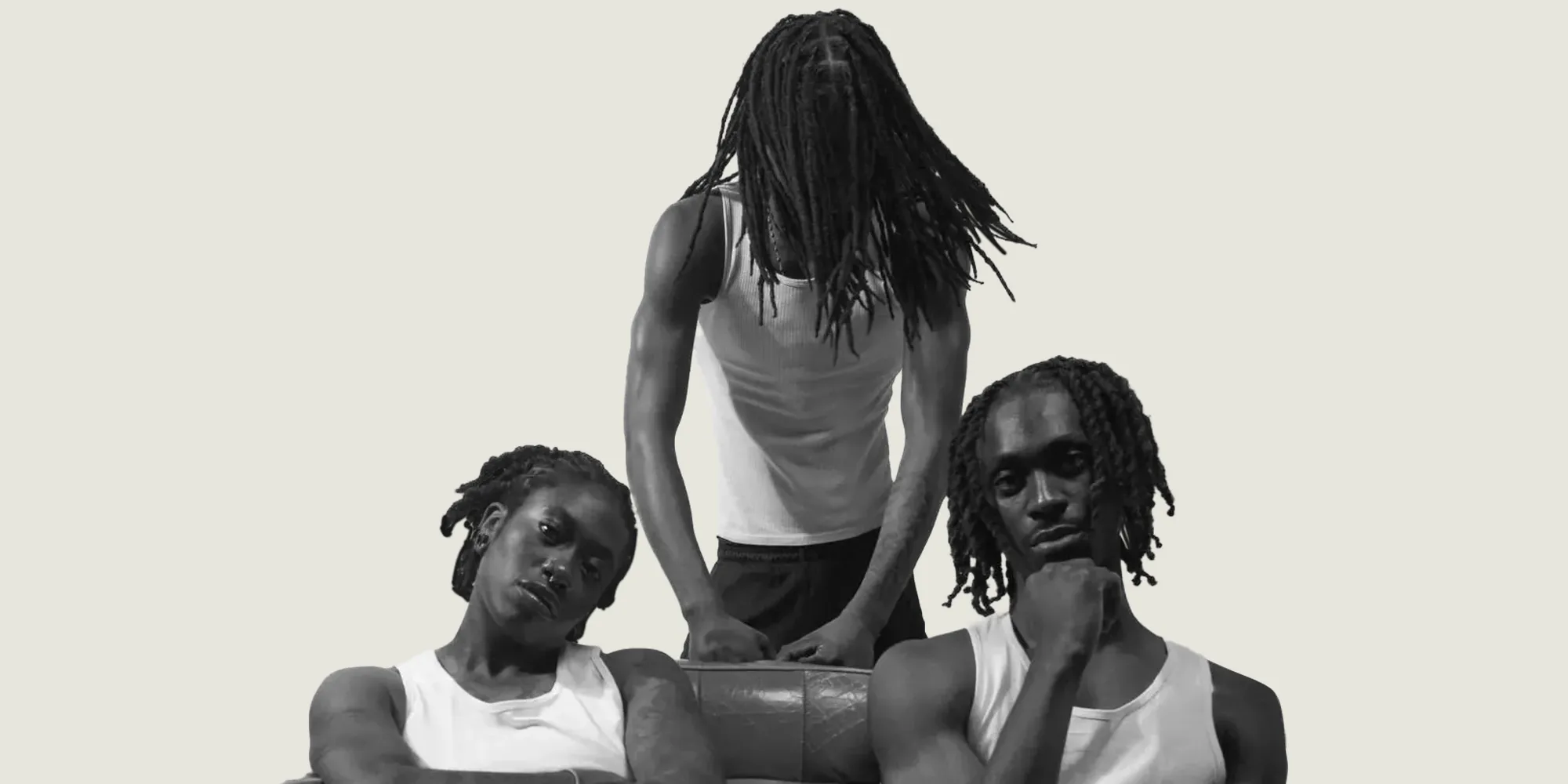 Black and white portrait of three people with locs of different lengths and styles